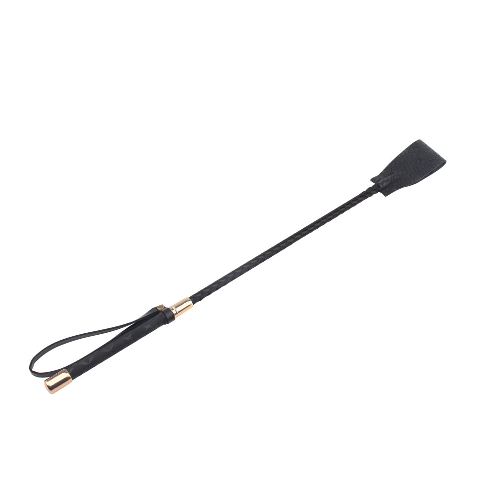 Close-up of the black riding crop handle, gold-tone collar and wrist loop on a white background.