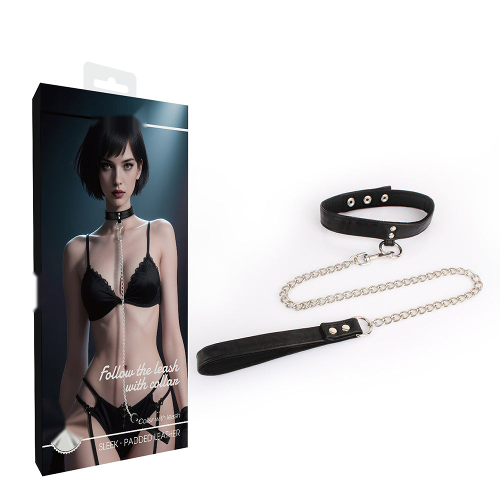 Woman wearing a black adjustable collar with silver-tone chain leash for adult role-play