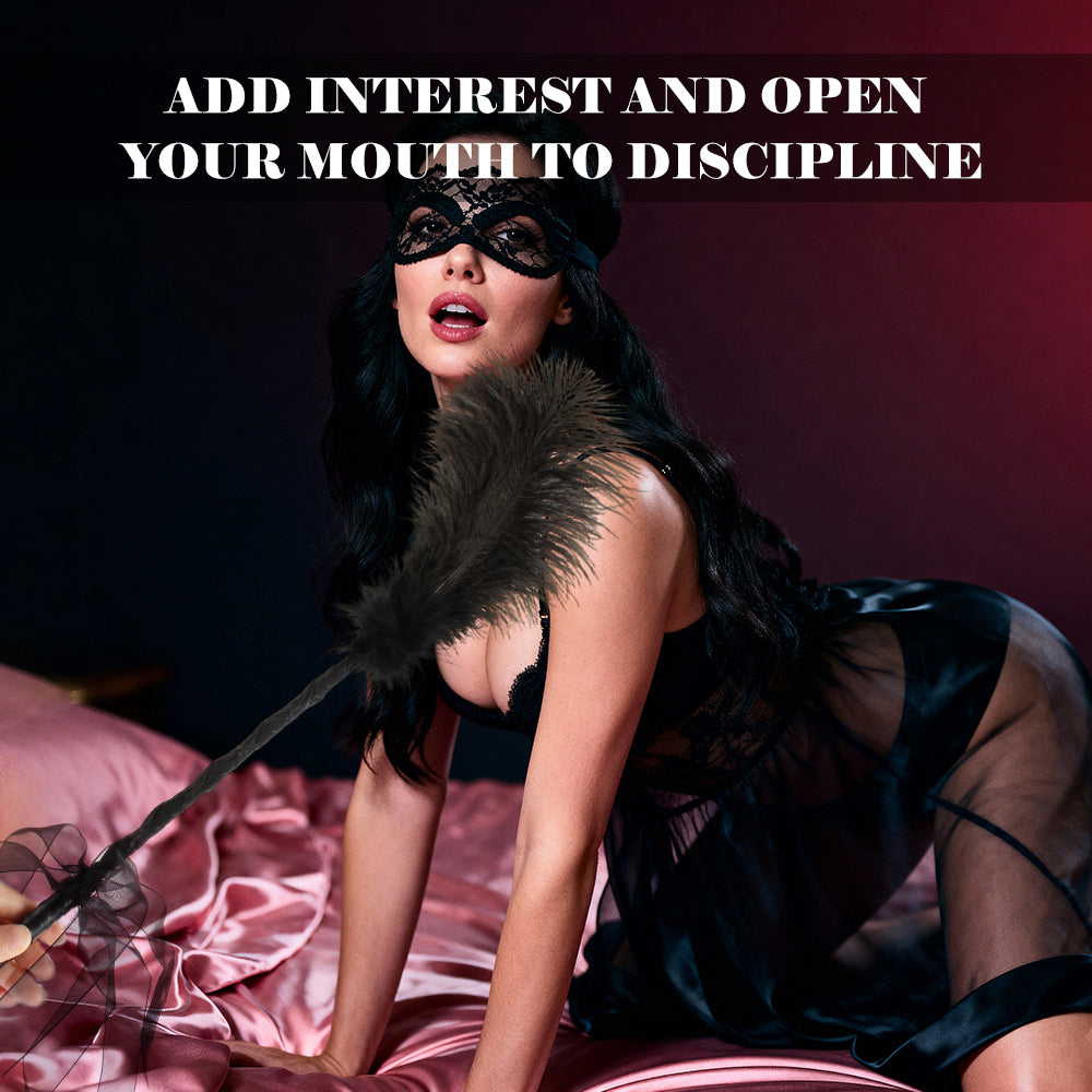 Black feather tickler used by a blindfolded model in a bedroom setting.